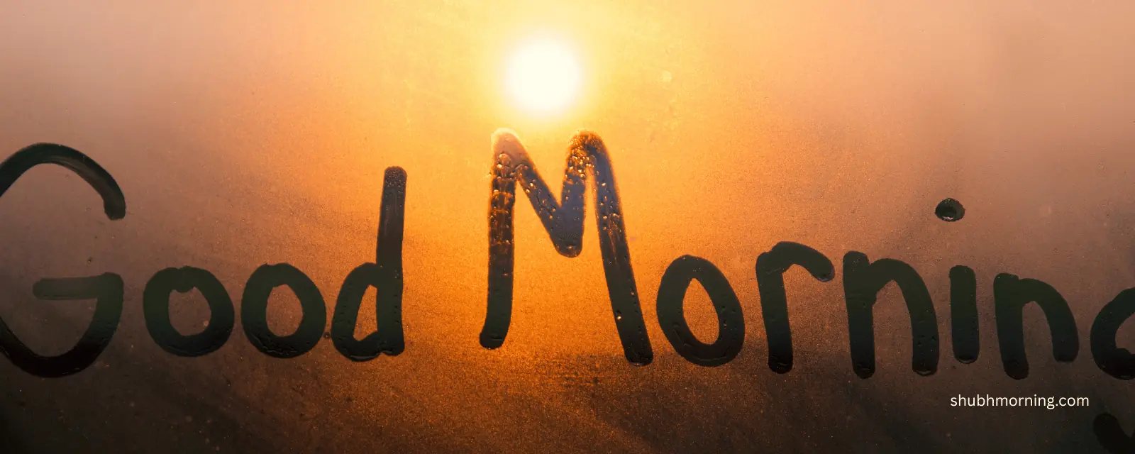 Good Morning written on a misted window with the sun rising behind it