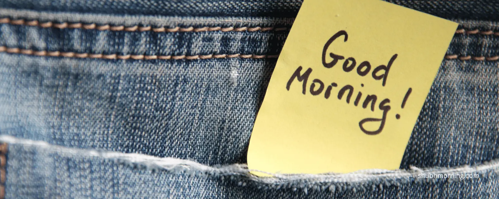 A yellow sticky note reading Good Morning tucked into a jeans pocket