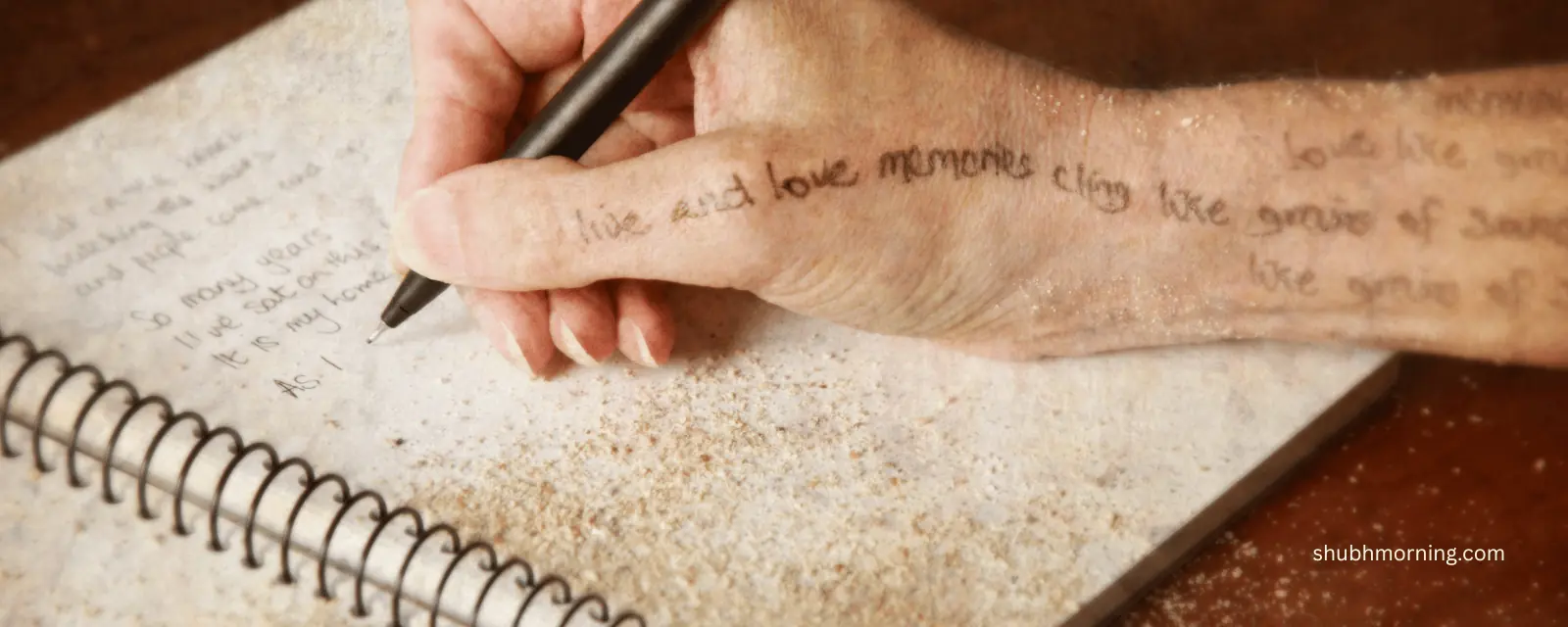 A hand writing verse in a notebook, lines of poetry inked across the wrist