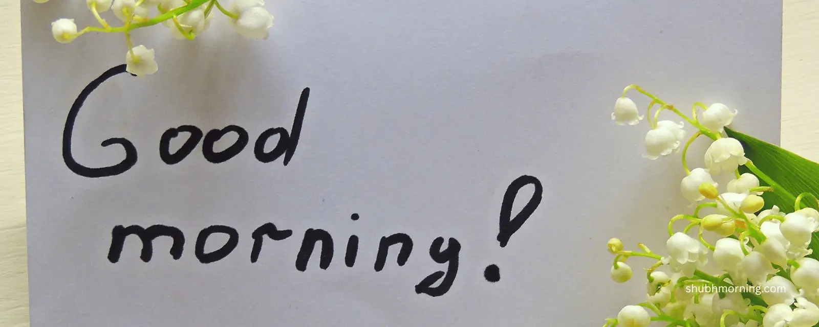 Good morning written on a card beside lily of the valley flowers